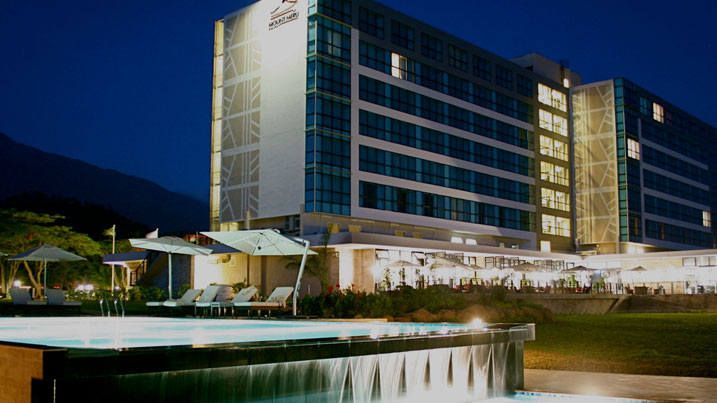Hotel exterior and swimming pool at dusk